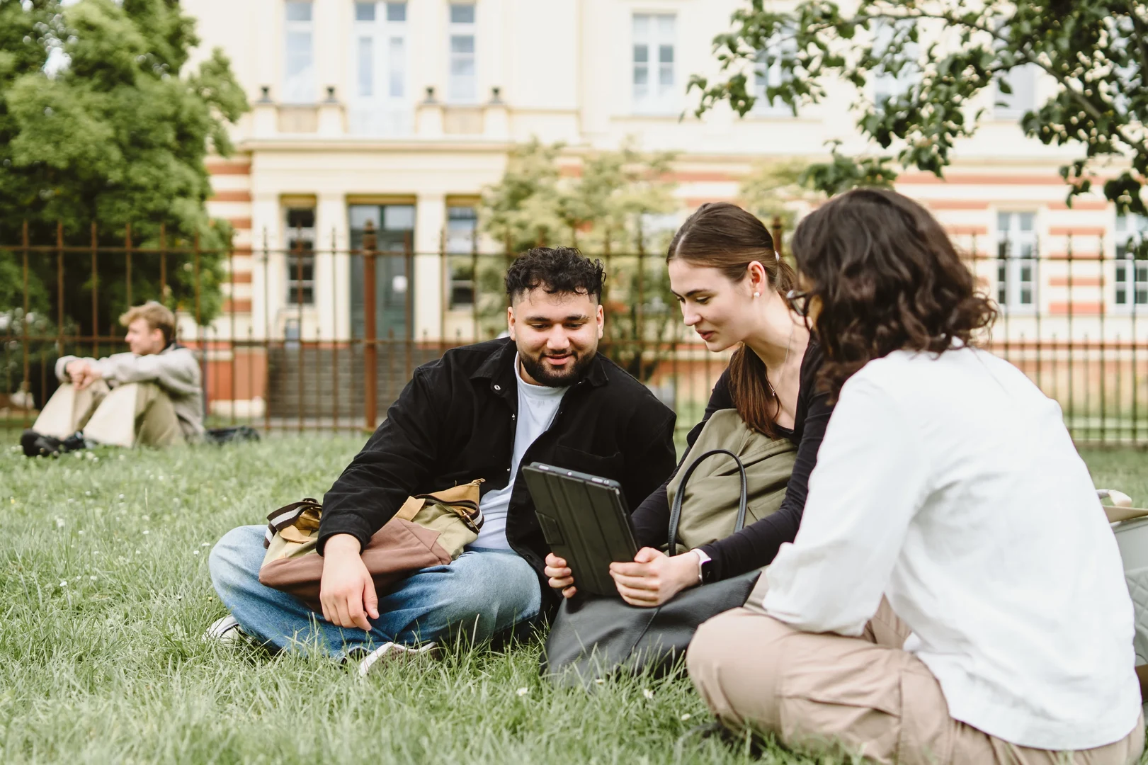 Eine Wissenschaftlerin und ein Wissenschaftler arbeiten hinter einer Glasfassade und mischen Chemikalien mit Großgeräten.